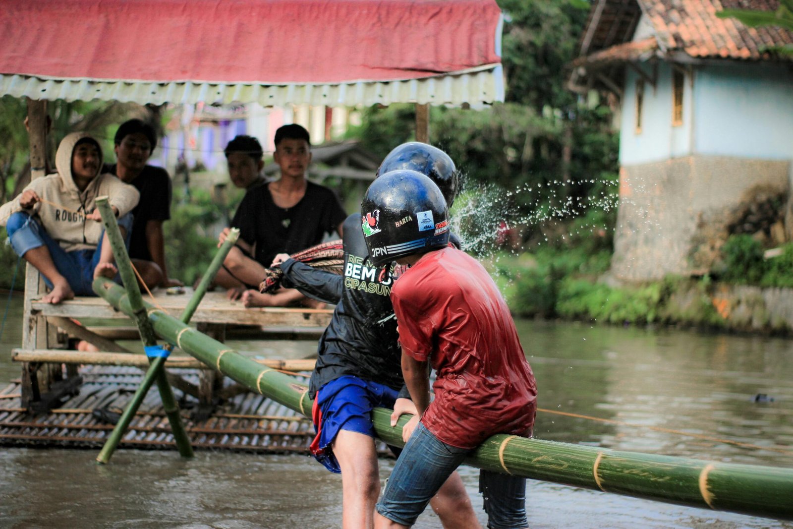 Traditional game on bamboo raft in Tasikmalaya, Indonesia, showcasing local culture and teamwork.