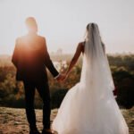 The bride and groom on their most important day in your life. They love each other, holding hands, kissing. It is the wedding dress and he in formal suits. They are ready to say to each other YES.